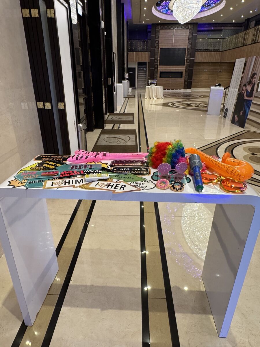 A table of SnapLUX props, signs, glasses and wigs set out at a venue